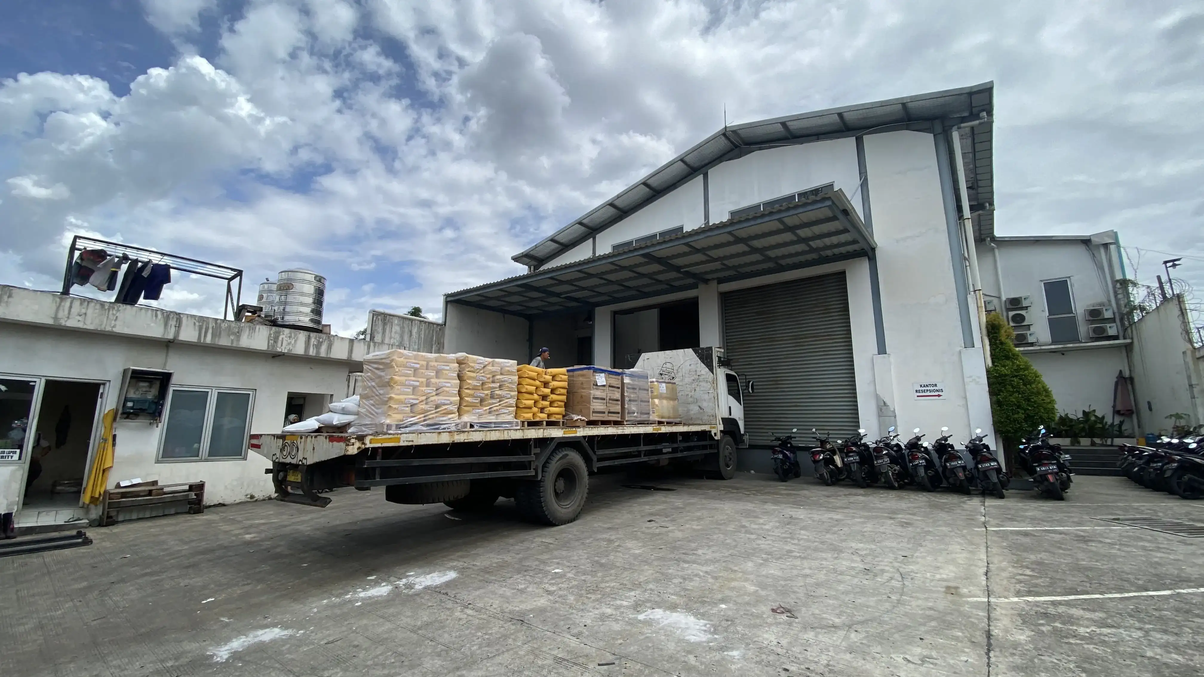 Truk bermuatan sak dan pail di depan gudang PT Jaya Abadi Makmur Sentosa